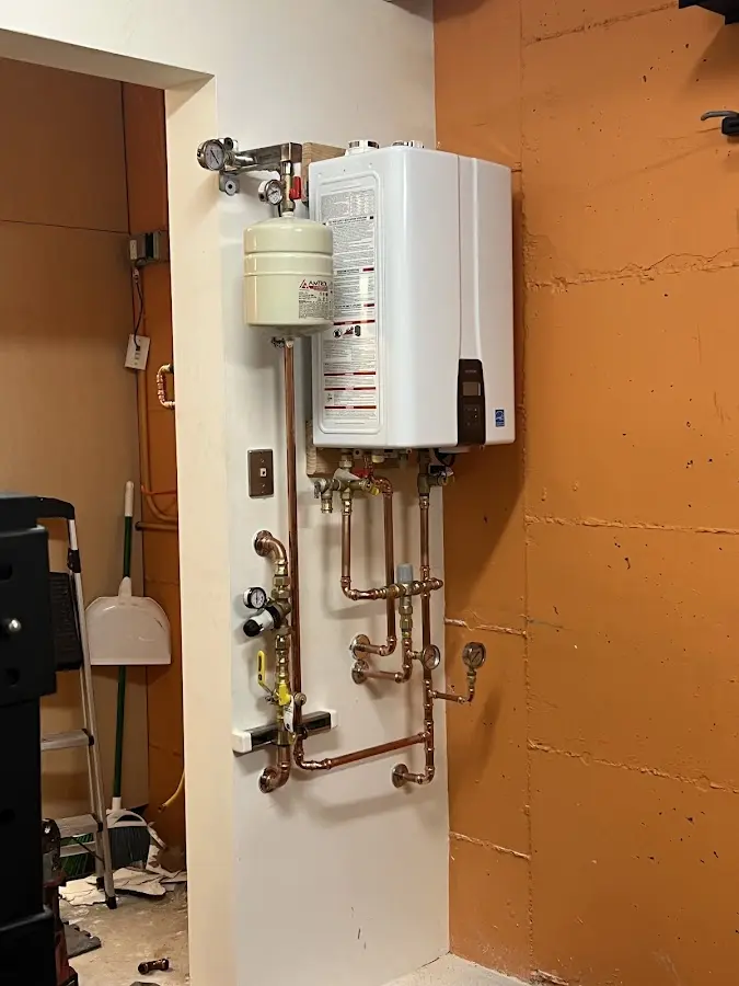 Plumbing technician inspecting water heater connections in Sarasota Springs
